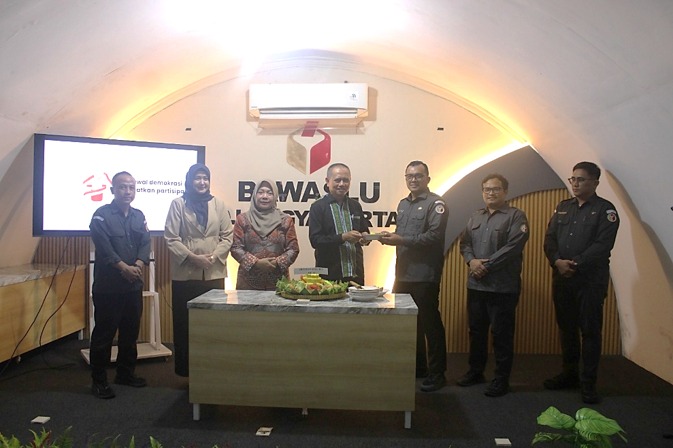 Ketua Bawaslu DIY memberikan tumpeng kepada Plt. Kepala Sekretariat Bawaslu DIY sebagai symbol sinergi yang terus berjalan di Bawaslu DIY dalam pengawasan pemilu